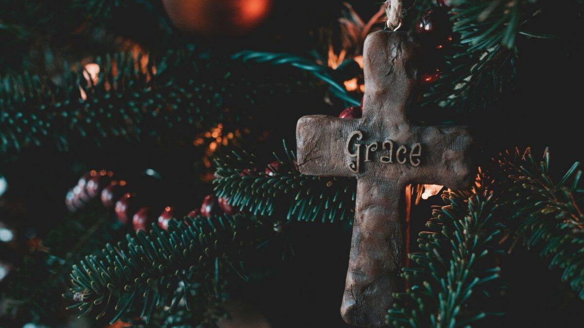 christian cross ornament on a Christmas tree